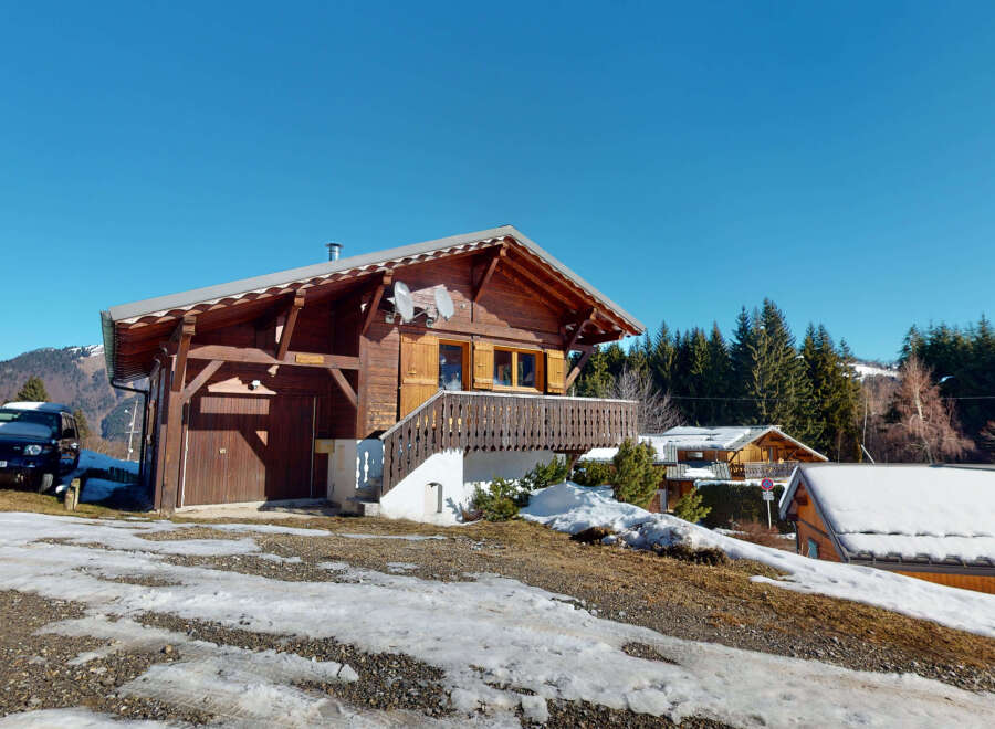 Discover a charming wooden chalet nestled in a picturesque mountain setting.
