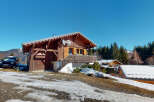 Discover a charming wooden chalet nestled in a picturesque mountain setting.