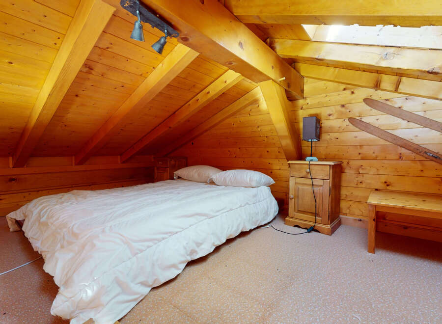 Cozy cabin bedroom with a rustic wooden interior.