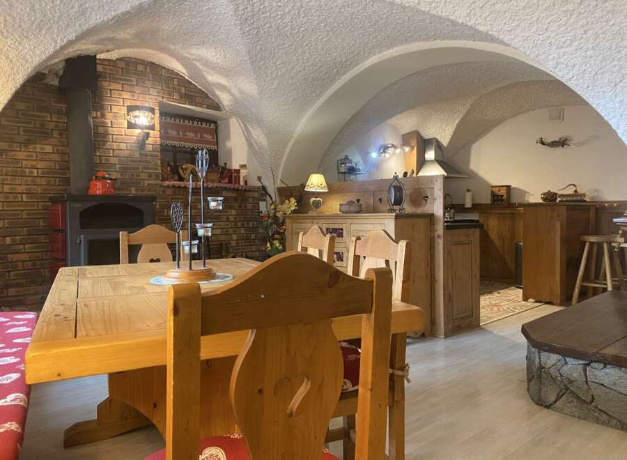 Rustic charm meets modern comfort in this unique chalet featuring a vaulted ceiling and exposed brick fireplace.