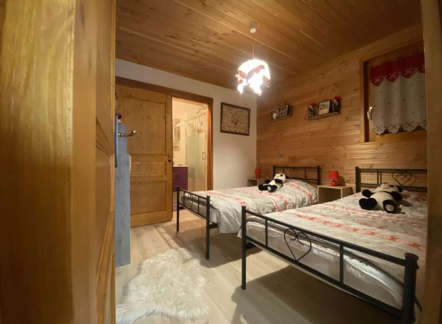 Cozy chalet bedroom with twin beds, perfect for a family getaway.