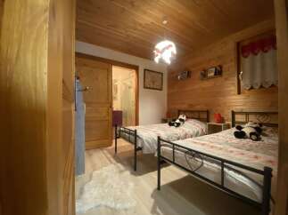 Cozy chalet bedroom with twin beds, perfect for a family getaway.