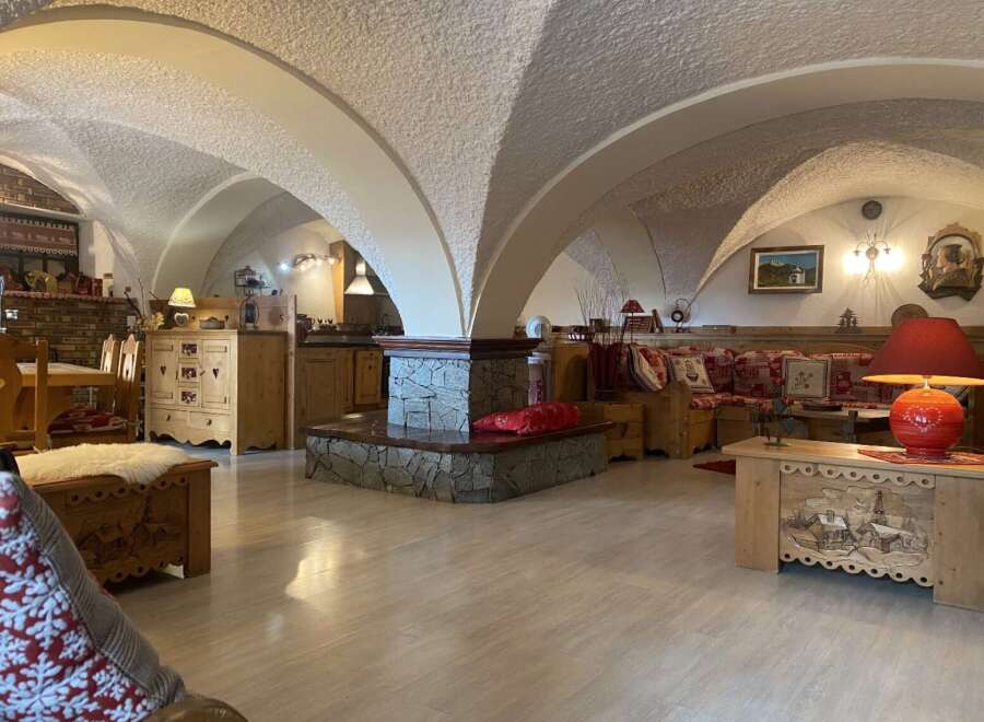 This stunning chalet boasts a unique vaulted ceiling and rustic wooden furnishings, creating a cozy and inviting atmosphere.