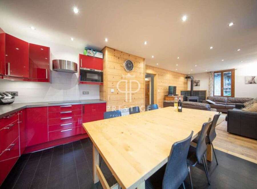 Discover the charm of this stunning property, featuring a modern kitchen with sleek red cabinetry and a spacious dining area perfect for entertaining.
