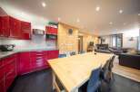 Discover the charm of this stunning property, featuring a modern kitchen with sleek red cabinetry and a spacious dining area perfect for entertaining.