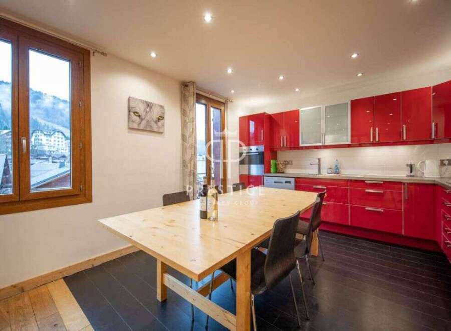 Discover a stunning kitchen with sleek red cabinetry and modern appliances.
