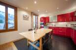 Discover a stunning kitchen with sleek red cabinetry and modern appliances.