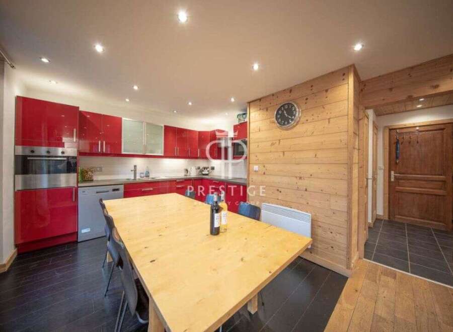 Discover this stunning property featuring a modern kitchen with sleek red cabinetry and stainless steel appliances.