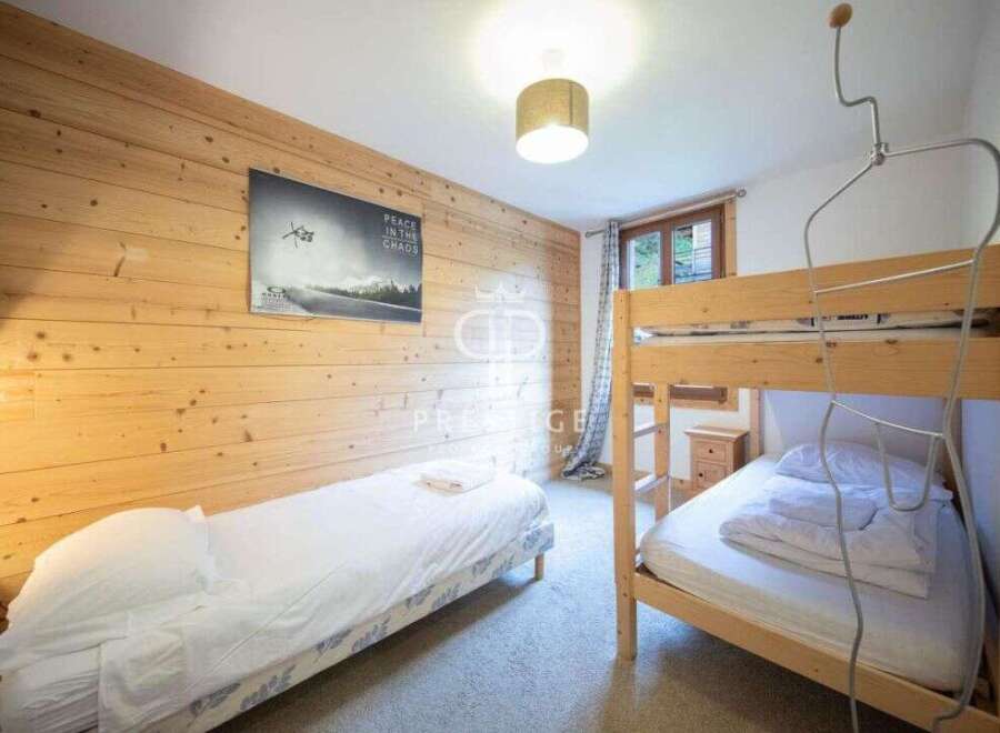 Cozy bedroom featuring wooden paneling and a bunk bed, perfect for a family getaway.