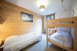Cozy bedroom featuring wooden paneling and a bunk bed, perfect for a family getaway.