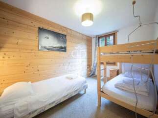 Cozy bedroom featuring wooden paneling and a bunk bed, perfect for a family getaway.