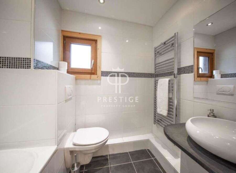 Discover a modern bathroom design with sleek white tiles and a touch of rustic charm.