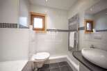 Discover a modern bathroom design with sleek white tiles and a touch of rustic charm.