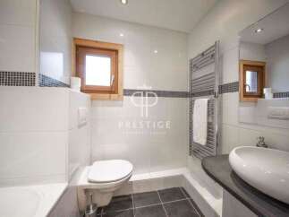 Discover a modern bathroom design with sleek white tiles and a touch of rustic charm.