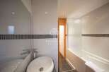 Discover a modern bathroom design featuring sleek white tiles and a stylish mosaic accent.