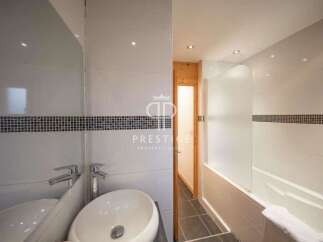 Discover a modern bathroom design featuring sleek white tiles and a stylish mosaic accent.
