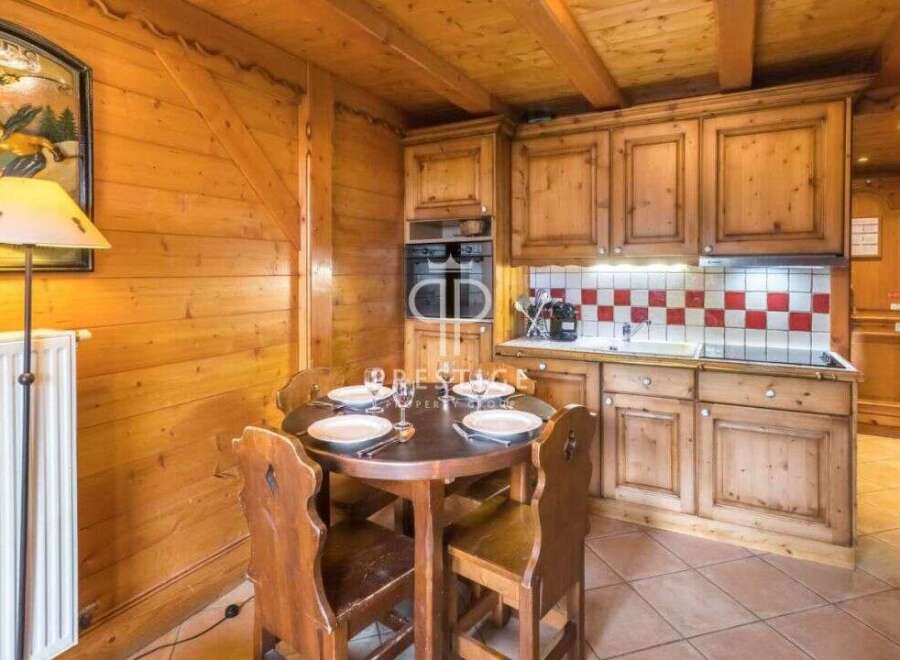 Cozy chalet kitchen with wooden cabinets and a charming dining area.