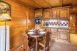 Cozy chalet kitchen with wooden cabinets and a charming dining area.