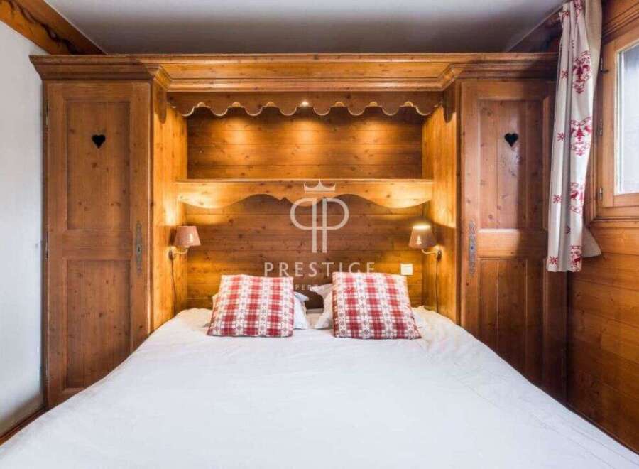 Discover the charm of this cozy bedroom, featuring a custom-built wooden headboard and matching wardrobes.