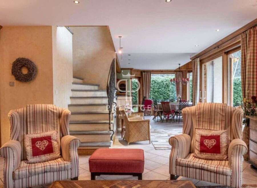 Discover the charm of this exquisite property, featuring a cozy living area with inviting armchairs and a stylish ottoman.
