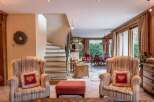 Discover the charm of this exquisite property, featuring a cozy living area with inviting armchairs and a stylish ottoman.