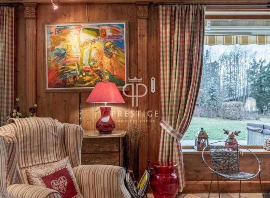 Experience the charm of this property, featuring a cozy living space with wooden paneling and a vibrant artwork.