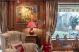 Experience the charm of this property, featuring a cozy living space with wooden paneling and a vibrant artwork.