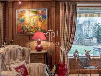 Experience the charm of this property, featuring a cozy living space with wooden paneling and a vibrant artwork.
