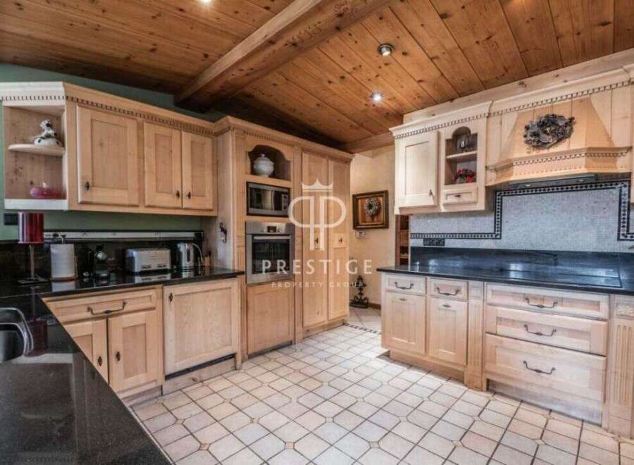 Step into a beautifully designed kitchen featuring custom cabinetry and sleek black countertops.