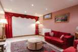 Step into luxury with this stunning property! Featuring a cozy living room with a vibrant red sofa and elegant curtains, perfect for relaxation.