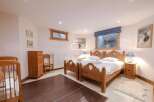 Discover a cozy bedroom retreat with charming wooden furniture and a touch of rustic elegance.