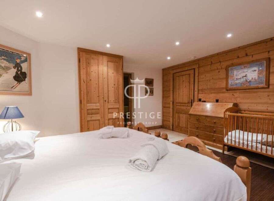 Discover the charm of this cozy bedroom, featuring a warm wooden interior and a comfortable bed.