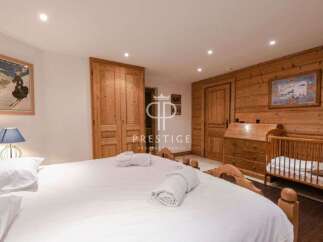 Discover the charm of this cozy bedroom, featuring a warm wooden interior and a comfortable bed.