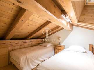 Discover the charm of this cozy bedroom featuring exposed wooden beams and a unique sloped ceiling.