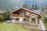 Discover a stunning wooden chalet nestled in a picturesque mountain setting.