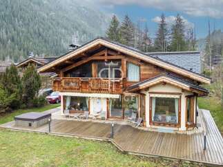 Discover a stunning wooden chalet nestled in a picturesque mountain setting.