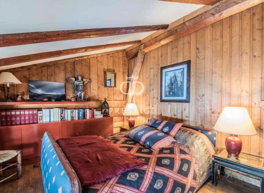 Discover the charm of this cozy bedroom with its rustic wooden walls and exposed beams.