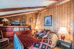 Discover the charm of this cozy bedroom with its rustic wooden walls and exposed beams.