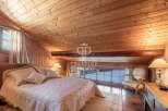 Discover the charm of this cozy bedroom with its wooden ceiling and walls, creating a warm and inviting atmosphere.