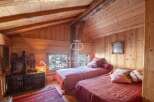 Cozy up in this charming bedroom with its warm wooden walls and inviting ambiance.