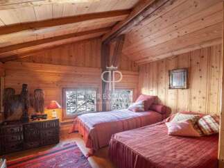 Cozy up in this charming bedroom with its warm wooden walls and inviting ambiance.