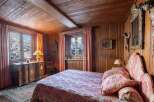 Step into a cozy bedroom retreat, adorned with rich wooden paneling and a charming, rustic ambiance.