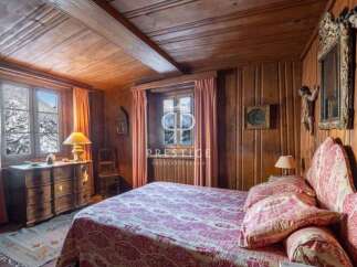 Step into a cozy bedroom retreat, adorned with rich wooden paneling and a charming, rustic ambiance.