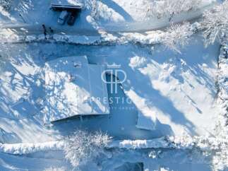 Discover a winter wonderland with this stunning property! Nestled in a snowy landscape, this home offers a serene escape.