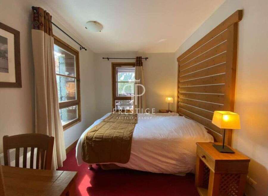 Discover a cozy bedroom with a rustic wooden headboard, creating a warm and inviting atmosphere.