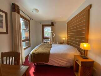 Discover a cozy bedroom with a rustic wooden headboard, creating a warm and inviting atmosphere.