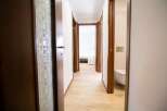 Explore this inviting hallway with its warm wooden doors and light-filled ambiance.