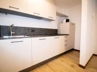 Modern kitchen with sleek white cabinets and dark countertops.
