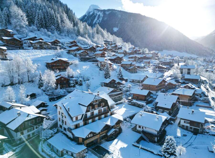 Discover the charm of a snow-covered village nestled in the mountains.