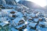 Discover the charm of a snow-covered village nestled in the mountains.
